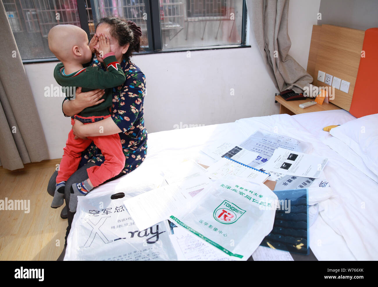 Three-year-old Uyghur boy diagnosed with rhabdomyosarcoma hugs his mother in Guangzhou city, south China's Guangdong province, 2 December 2017.   Thre Stock Photo