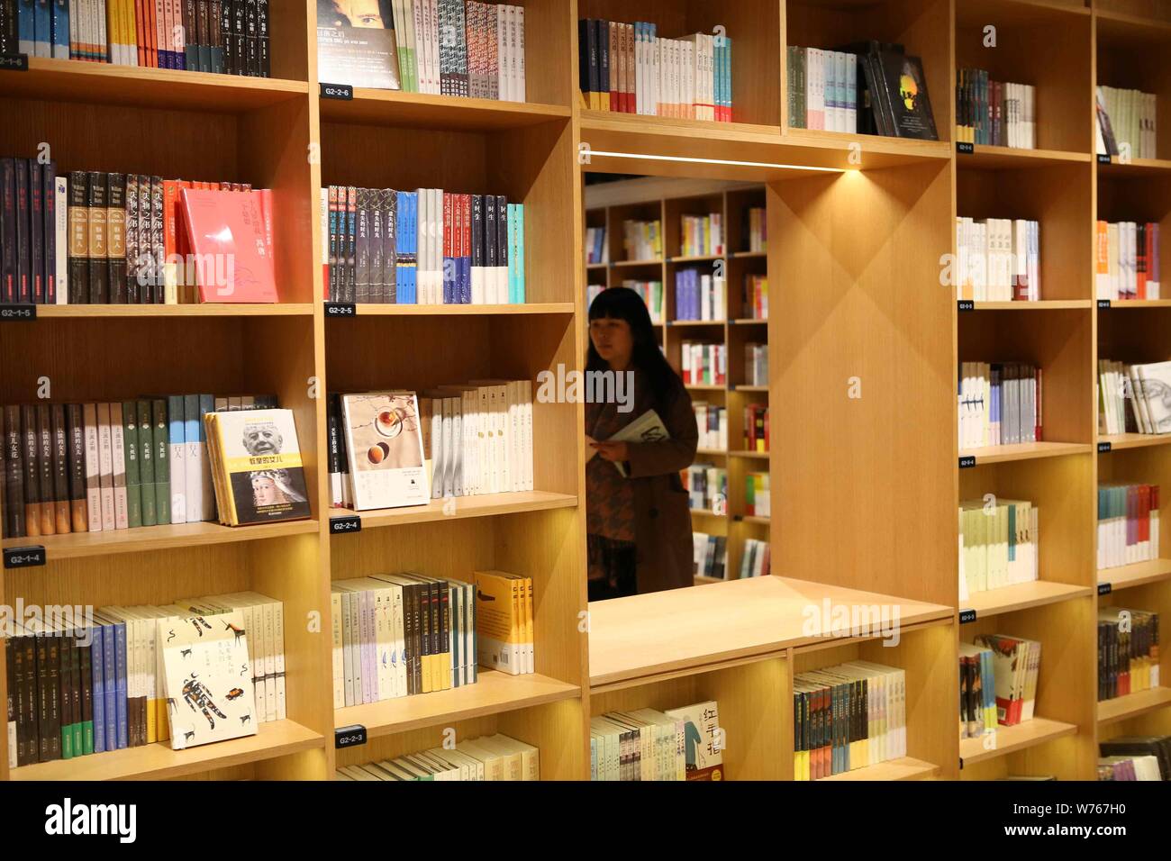 A customer reads books in a branch of Xinhua Bookstore, the state-owned ...