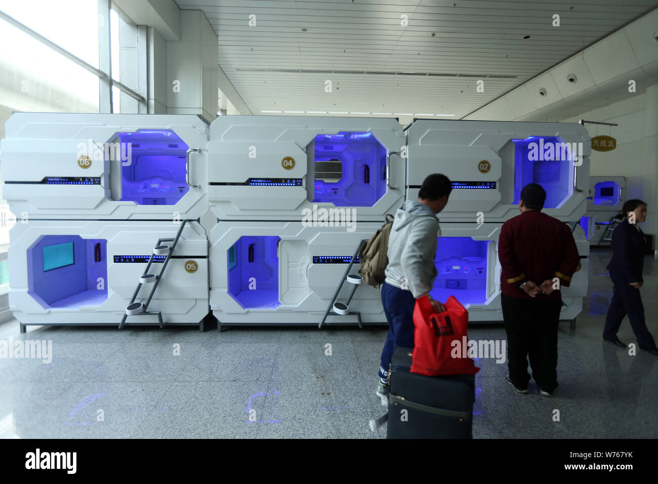 Passengers look at sleeping capsules in the arrival hall of Terminal 3