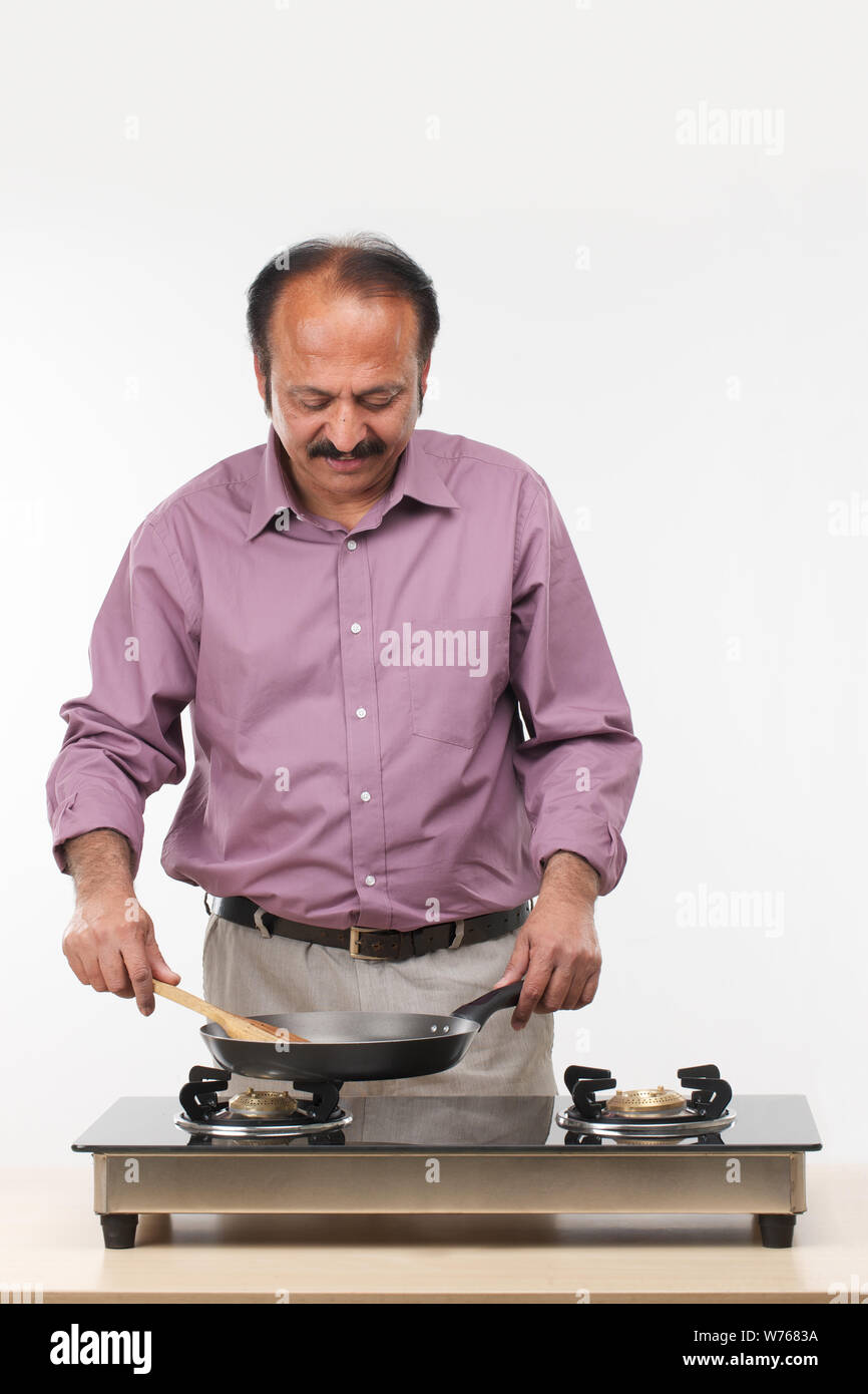Mature man cooking food in a kitchen Stock Photo