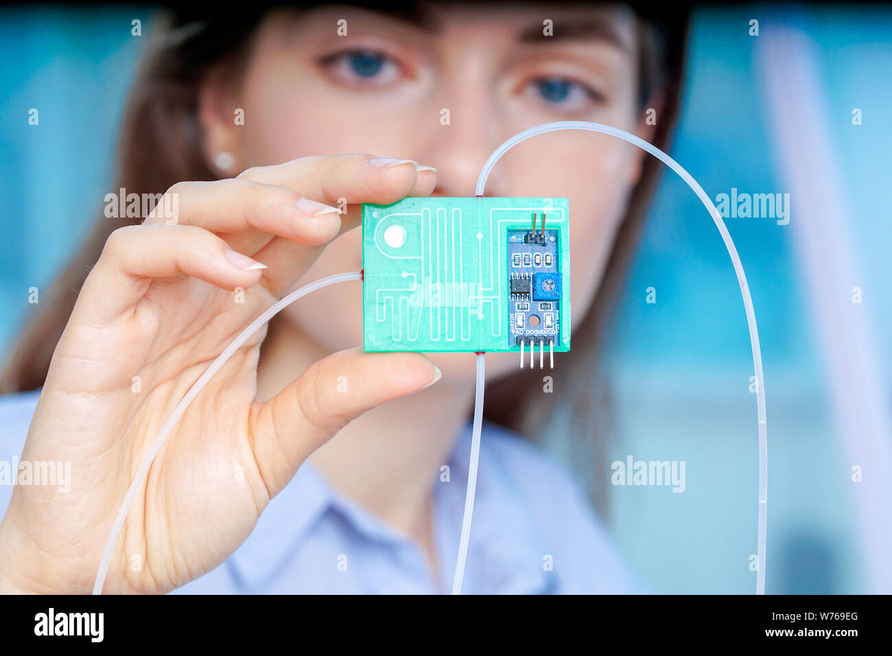 Girl holding polymers Bio-MEMS biomedical microelectromechanical systems / LOC lab-on-a-chip device (concept design) Stock Photo