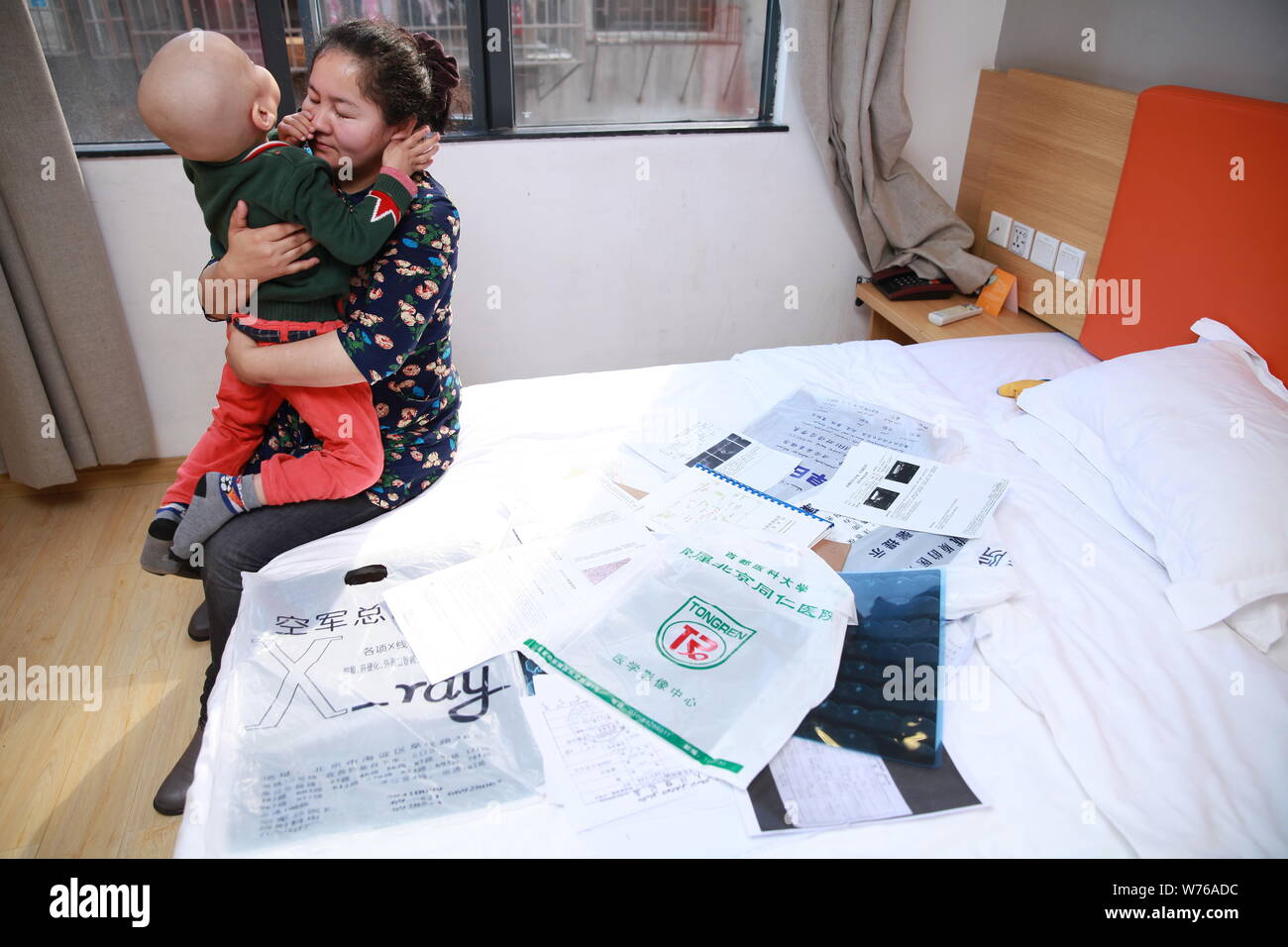 Three-year-old Uyghur boy diagnosed with rhabdomyosarcoma hugs his mother in Guangzhou city, south China's Guangdong province, 2 December 2017.   Thre Stock Photo