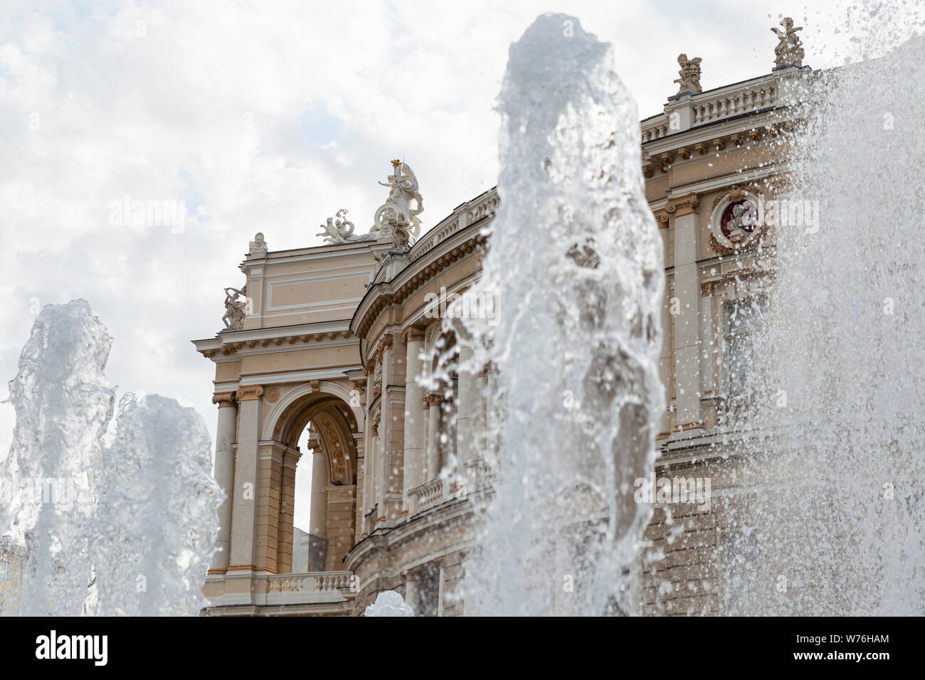 Ukraine, Odessa, 11th of June 2019. Side view of the national academic opera building through the fountain in the park. Stock Photo