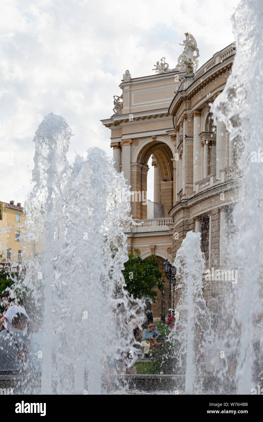 Ukraine, Odessa, 11th of June 2019. Side view of the national academic opera building through the fountain in the park. Stock Photo