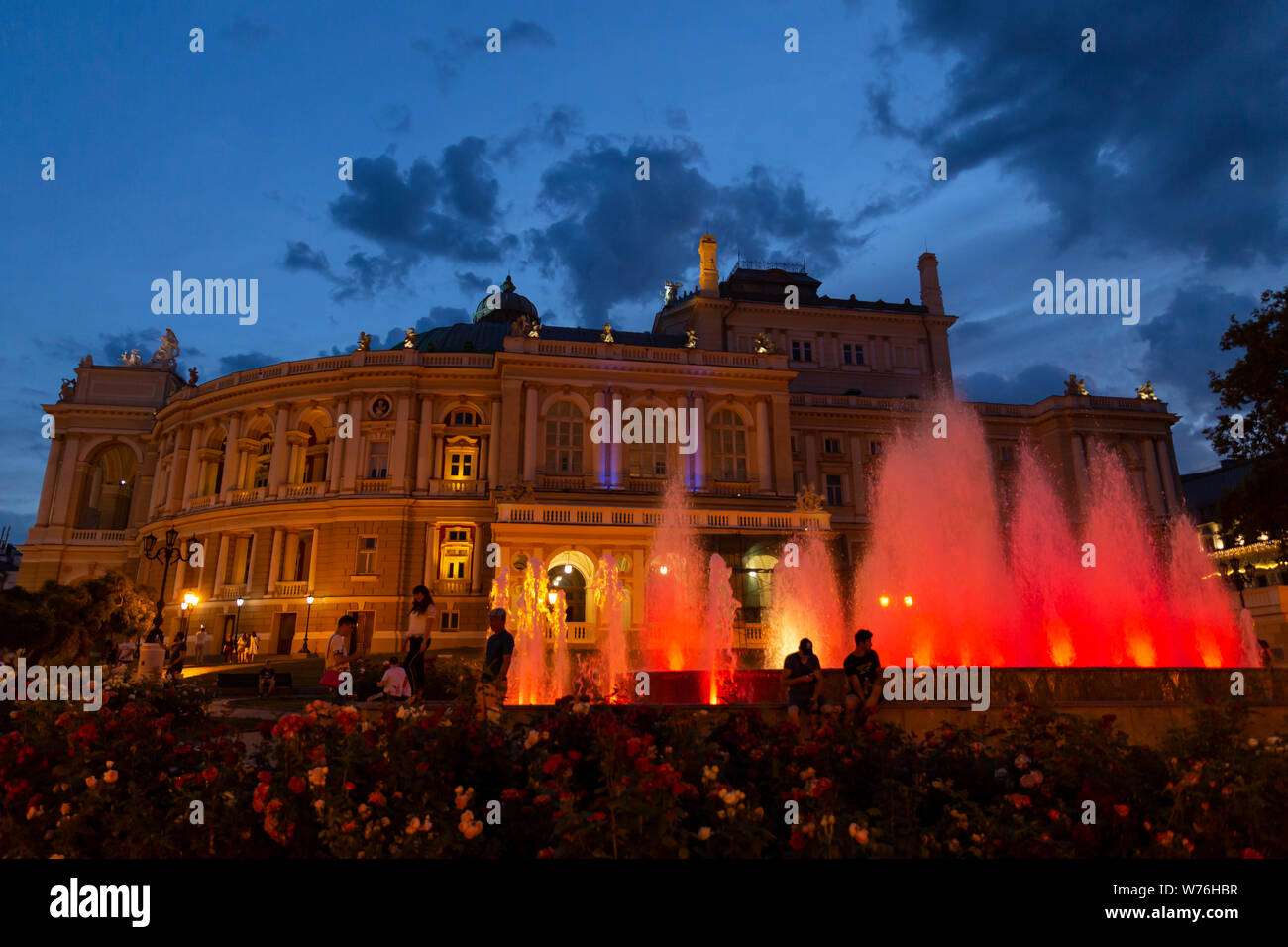 Ukraine, Odessa, 11th of June 2019. Side view of the national academic opera building and the colorful illuminated fountain at sunset Stock Photo