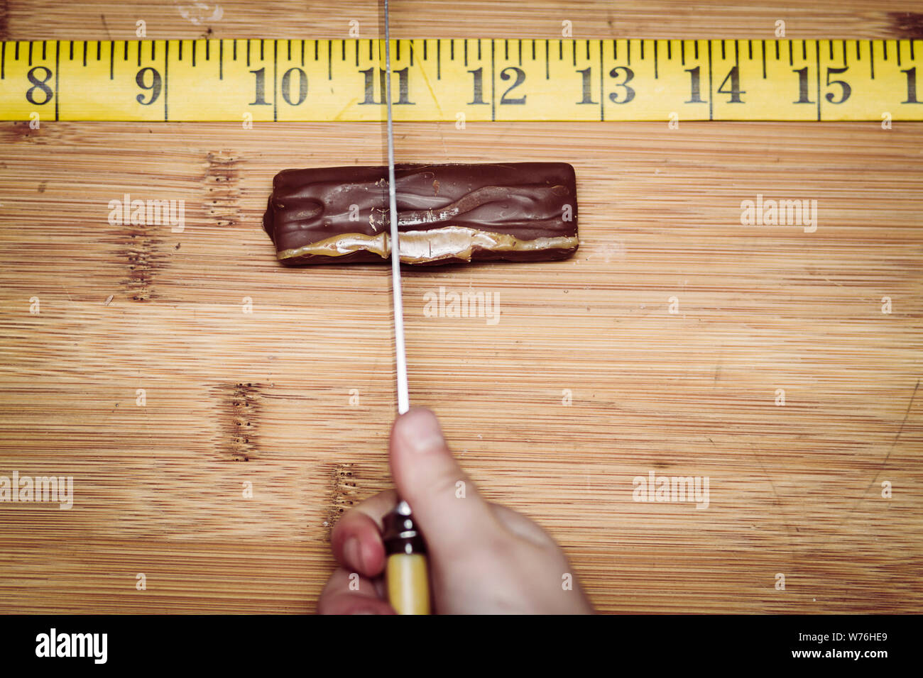 A chocolate bar being cut into exact equal portions. Stock Photo