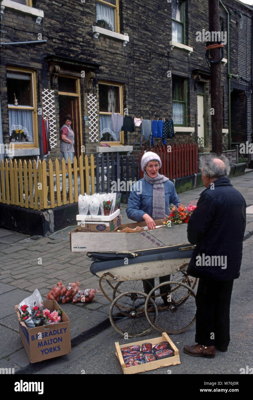 a neighbourhood in Bradford England in the late seventies. A man selling flowers and strawberries in an old baby carriage. Stock Photo