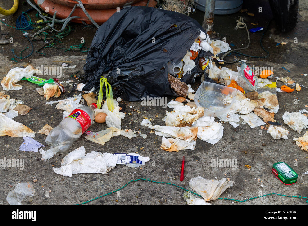 Dumped refuse or trash bag spilling household waste or garbage. Stock Photo