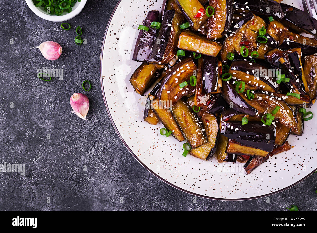 Hot spicy stew eggplant in Korean style with green onion. Aubergine saute. Vegan food. Top view