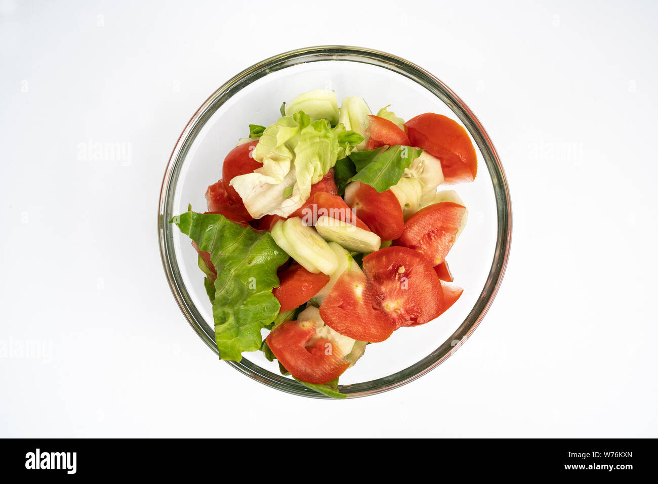 a fresh lettuce, tomato and cucumber salad in a glass bowl Stock Photo