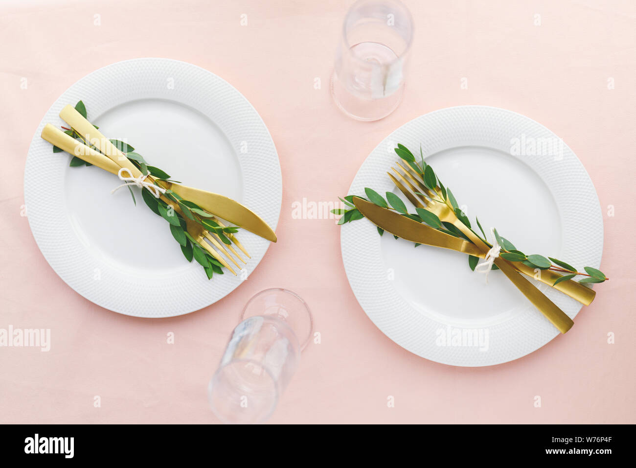 Festive table setting for celebrate event or family dinner with two plates and golden cutlery. Top view, flat lay. Stock Photo