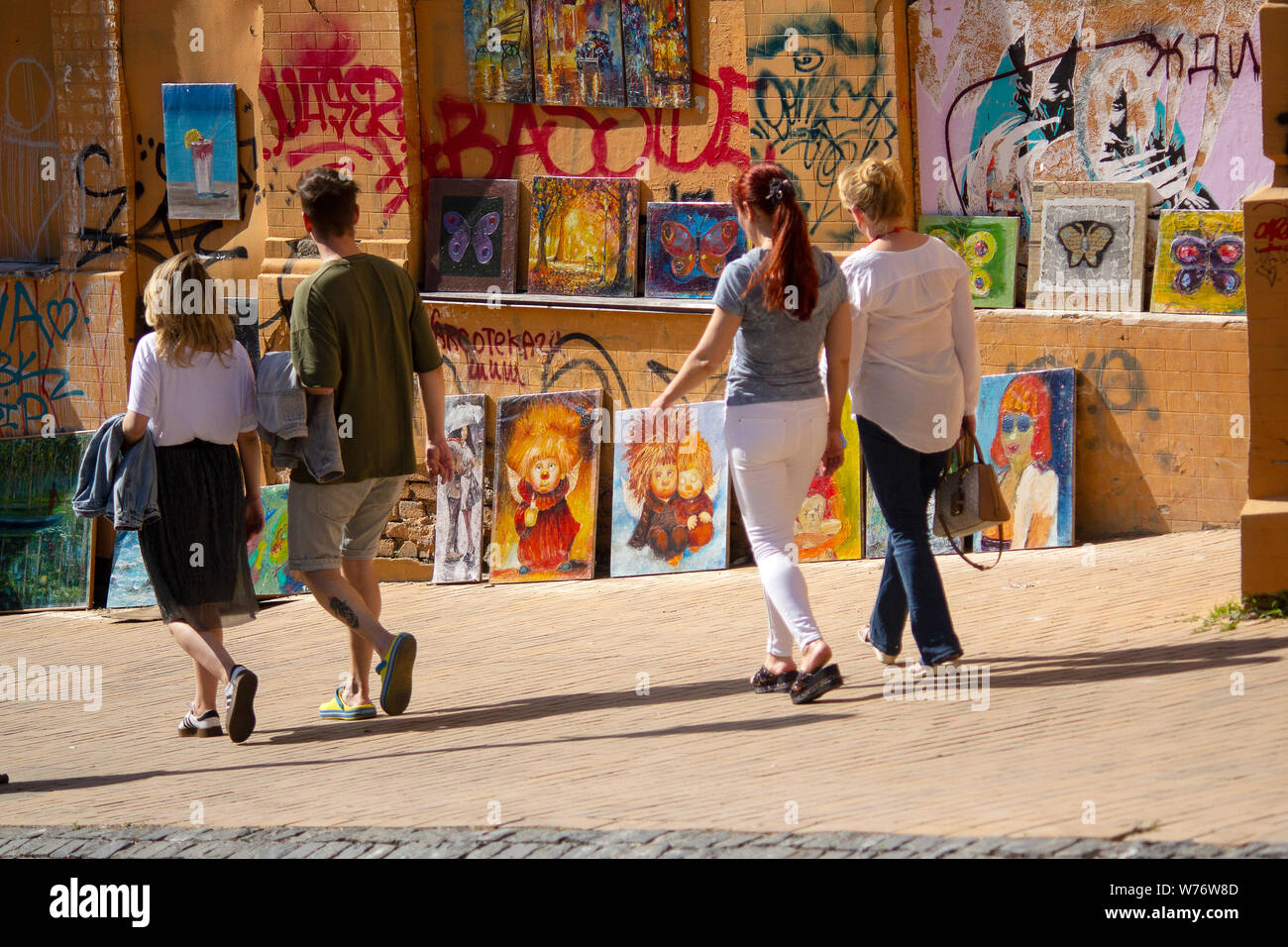 Kiev, Ukraine - May 19, 2019: People pass near paintings sold by artists on St. Andrew Descent Stock Photo