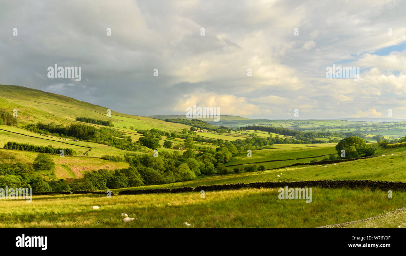 Long-distance picturesque evening view to Wharfedale (rolling clouds & hills, green pasture, sunlit valley) - Beamsley, Yorkshire Dales, England, UK. Stock Photo