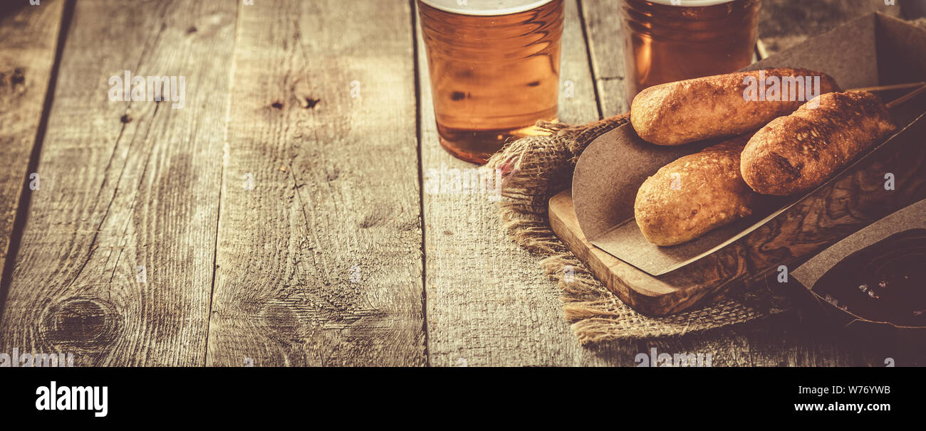 Corn dogs and beer on rustic background Stock Photo