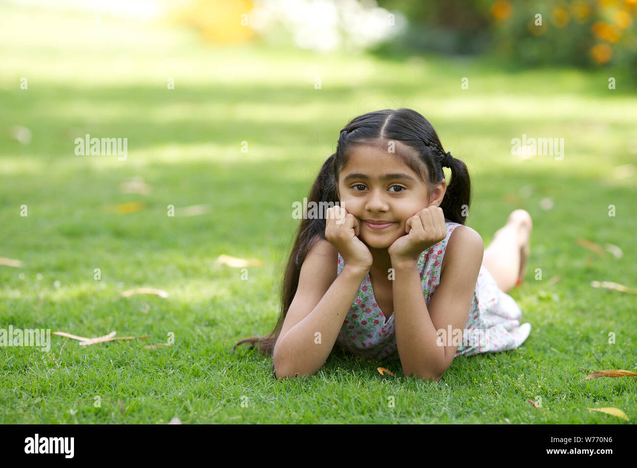 Girl lying on grass in a park Stock Photo - Alamy