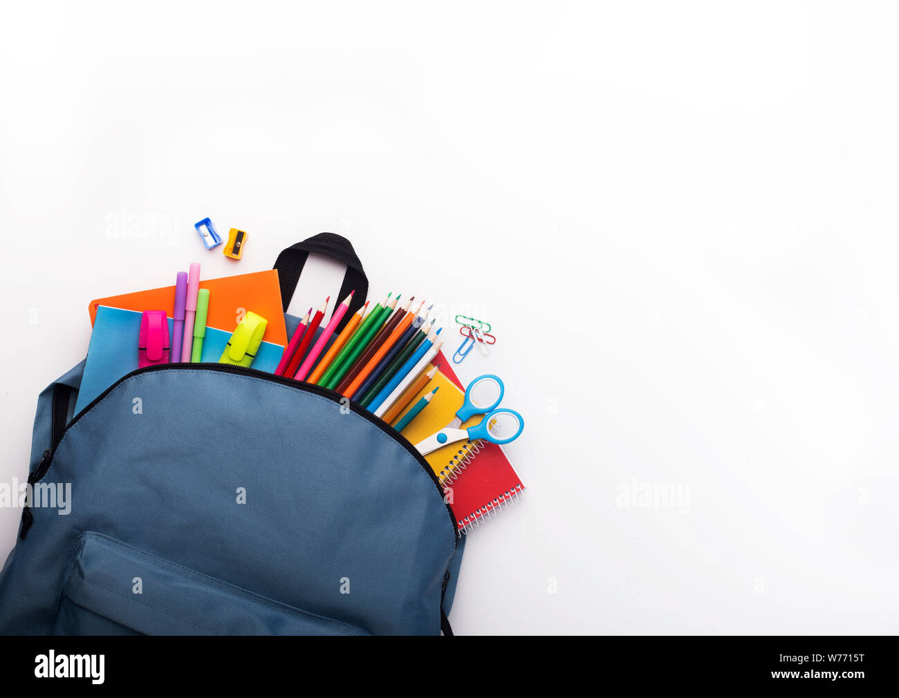 School backpack with colored stationery on white background Stock Photo