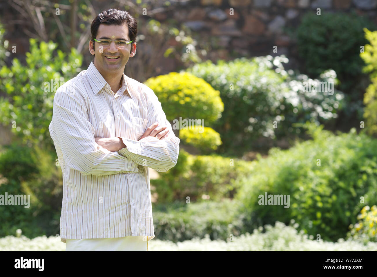 South Indian man standing with arms crossed Stock Photo - Alamy