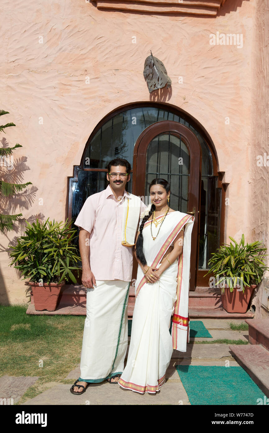 South Indian couple standing together in front of house Stock Photo - Alamy