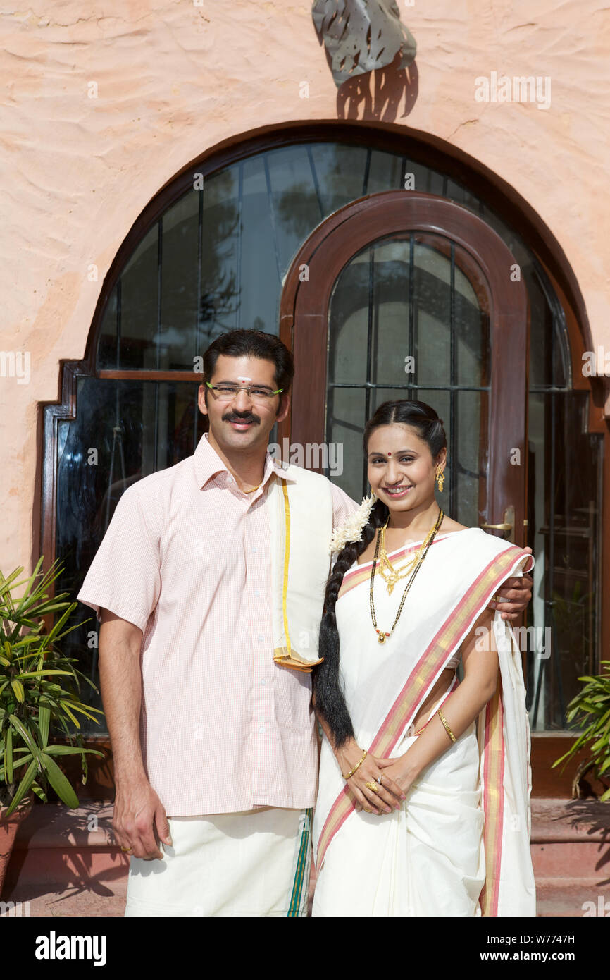 South Indian couple standing together in front of house Stock Photo - Alamy