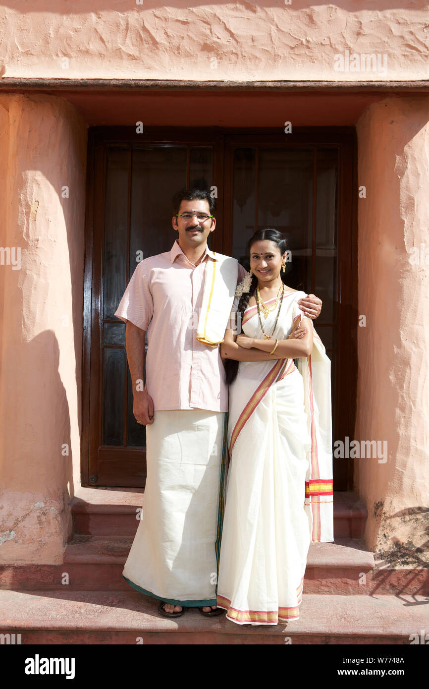 South Indian couple standing together in front of house Stock Photo - Alamy