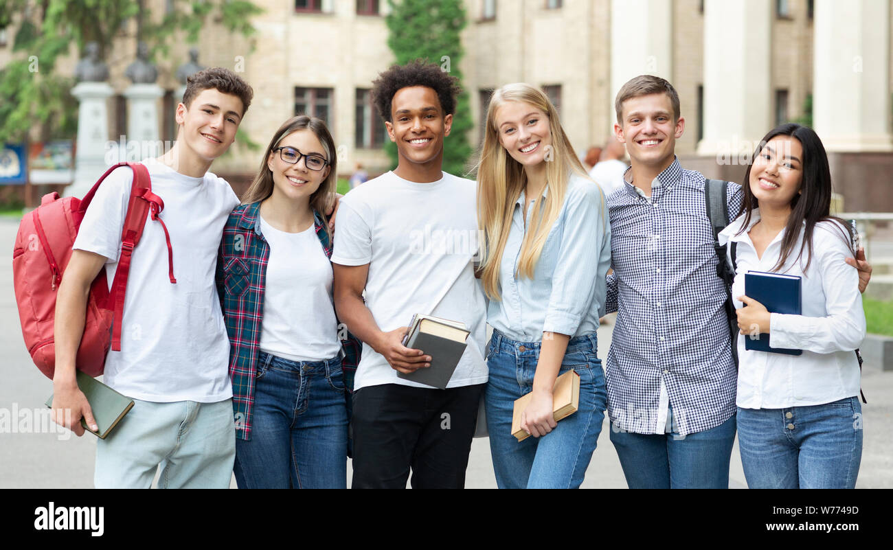 Diverse students in campus, posing in front of university Stock Photo