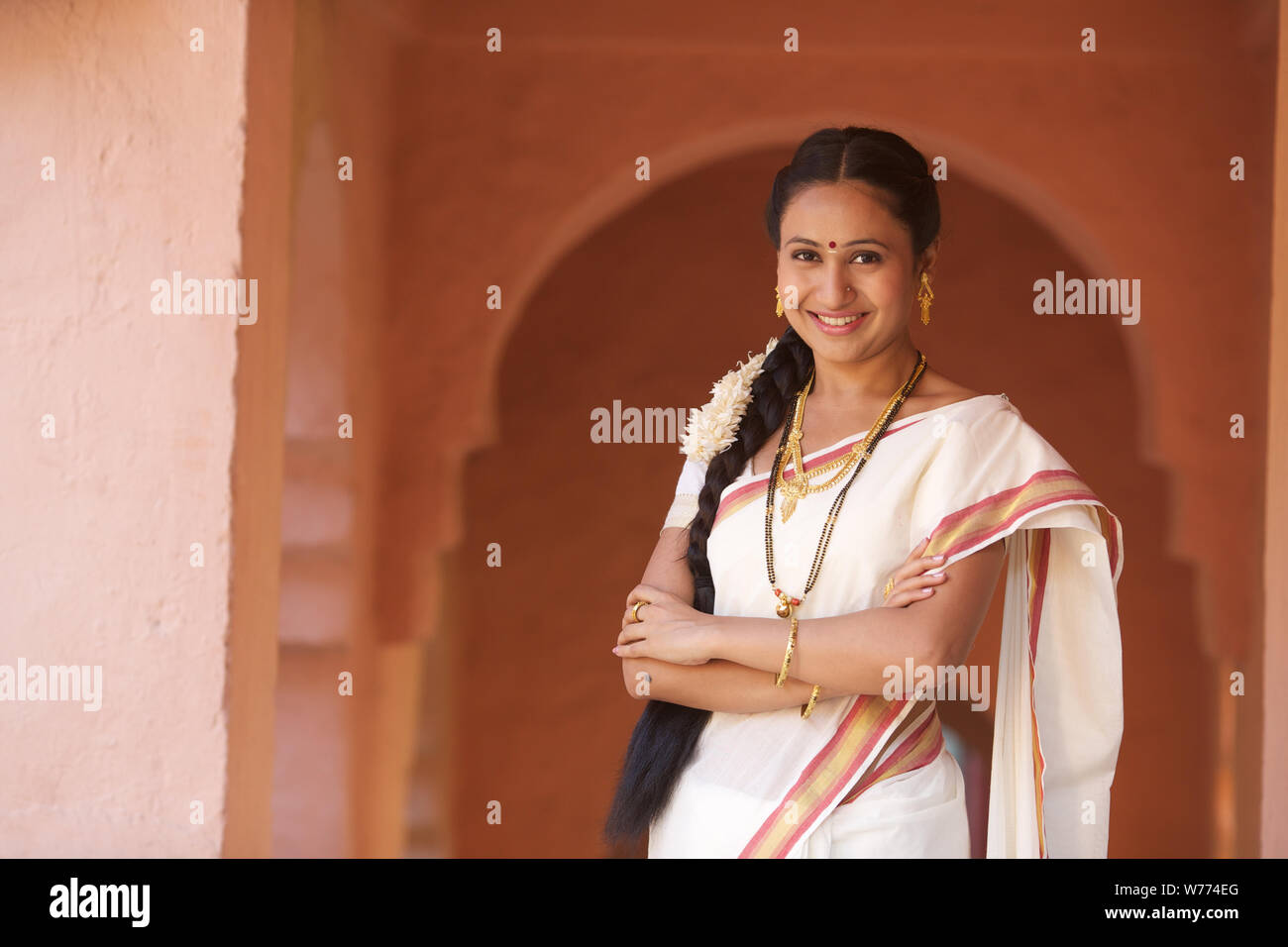 South Indian woman standing with her arms crossed Stock Photo - Alamy