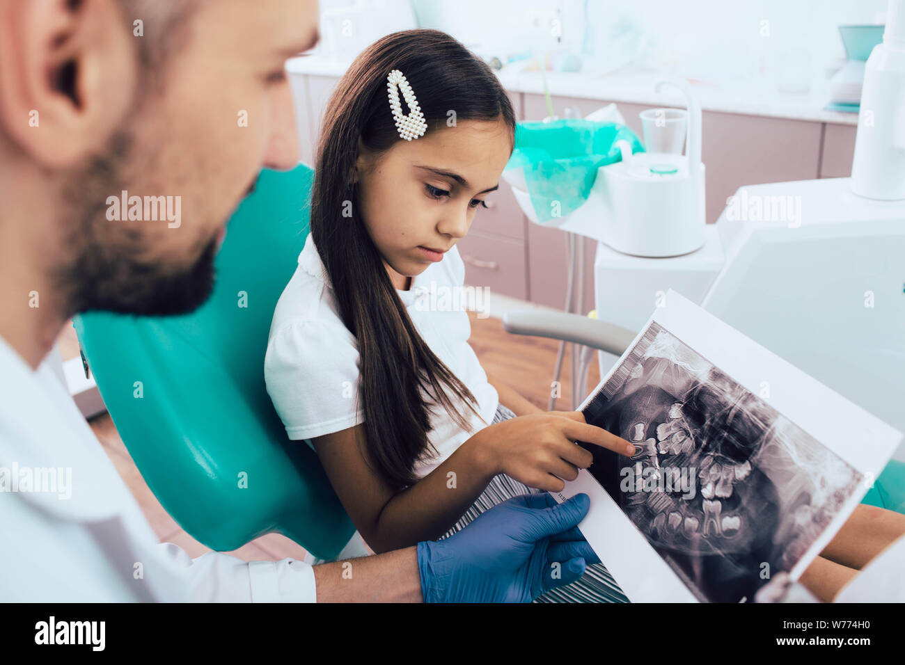 mixed race little girl with her x-ray teeth picture.Pediatric dentistry Stock Photo