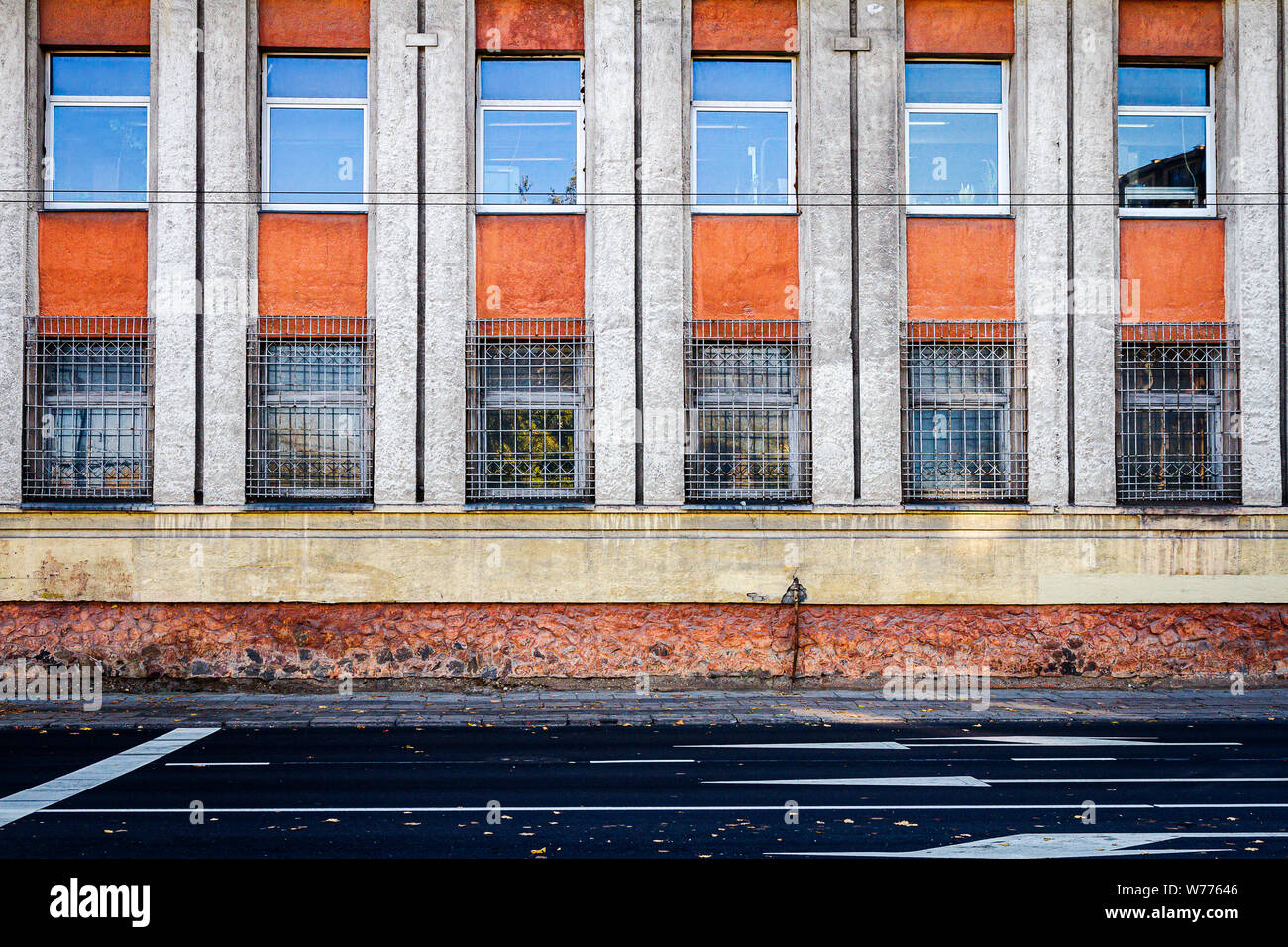 Close up of yellow and red wall with lots of windows. Architectural