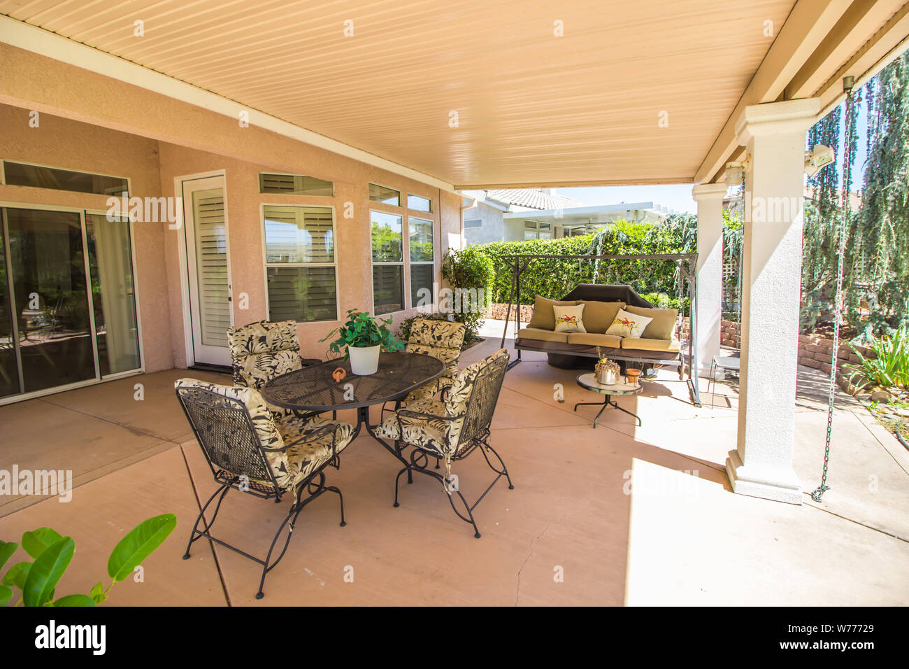 Modern Rear Yard Covered Patio With Wrought Iron Furniture Stock Photo