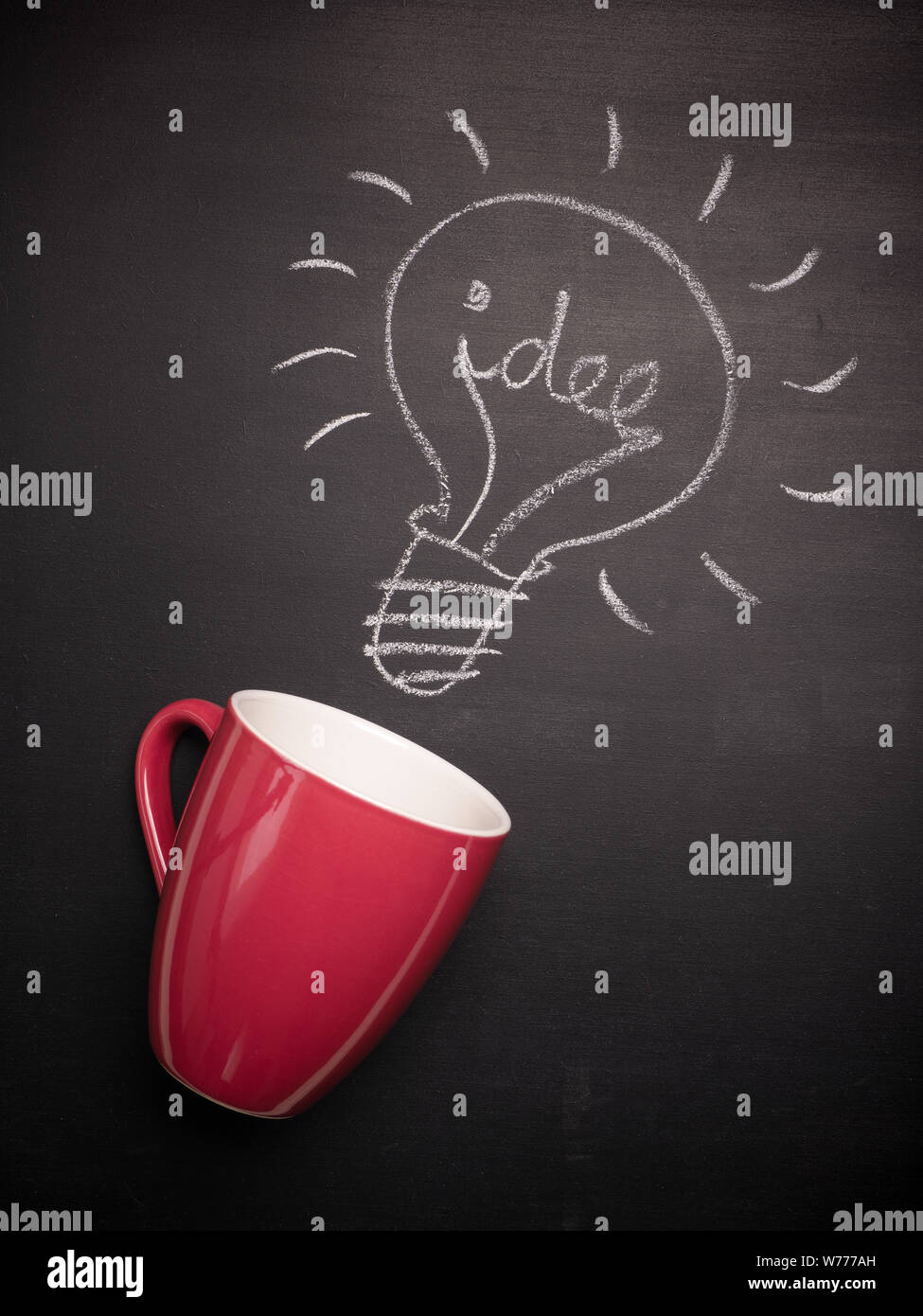 Coffee cup with a light bulb and the German word idea on a chalkboard, great idea concept Stock Photo