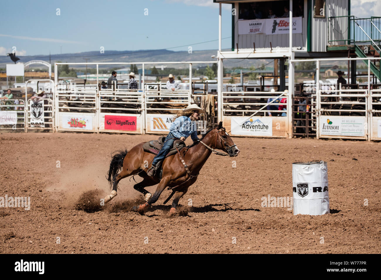A charging barrel racer at a large outdoor rodeo that's a feature of ...