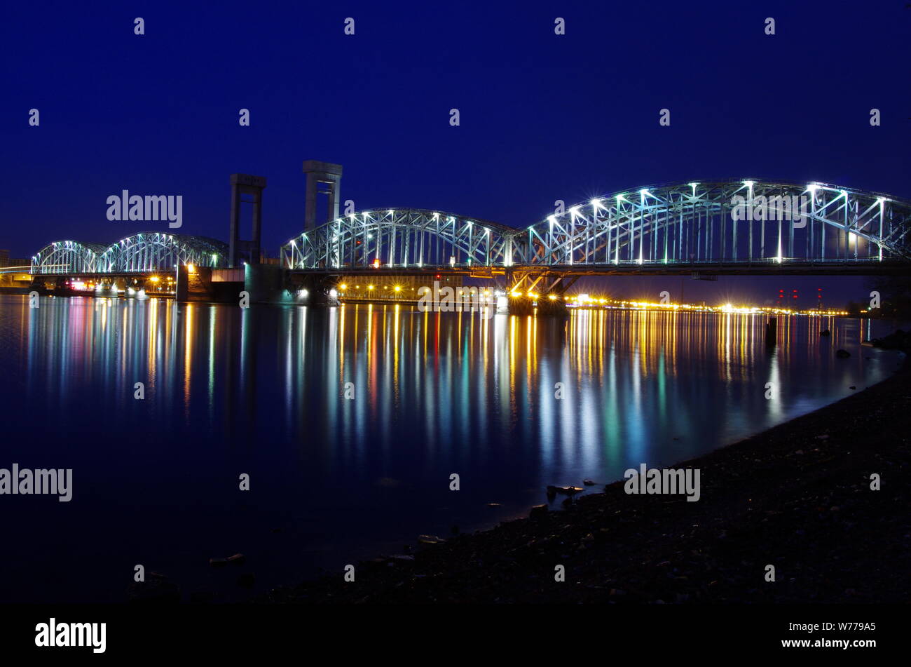 Finland Railway Bridge over Neva river, Saint-Petersburg, summer night, calm water surface, Russia Stock Photo