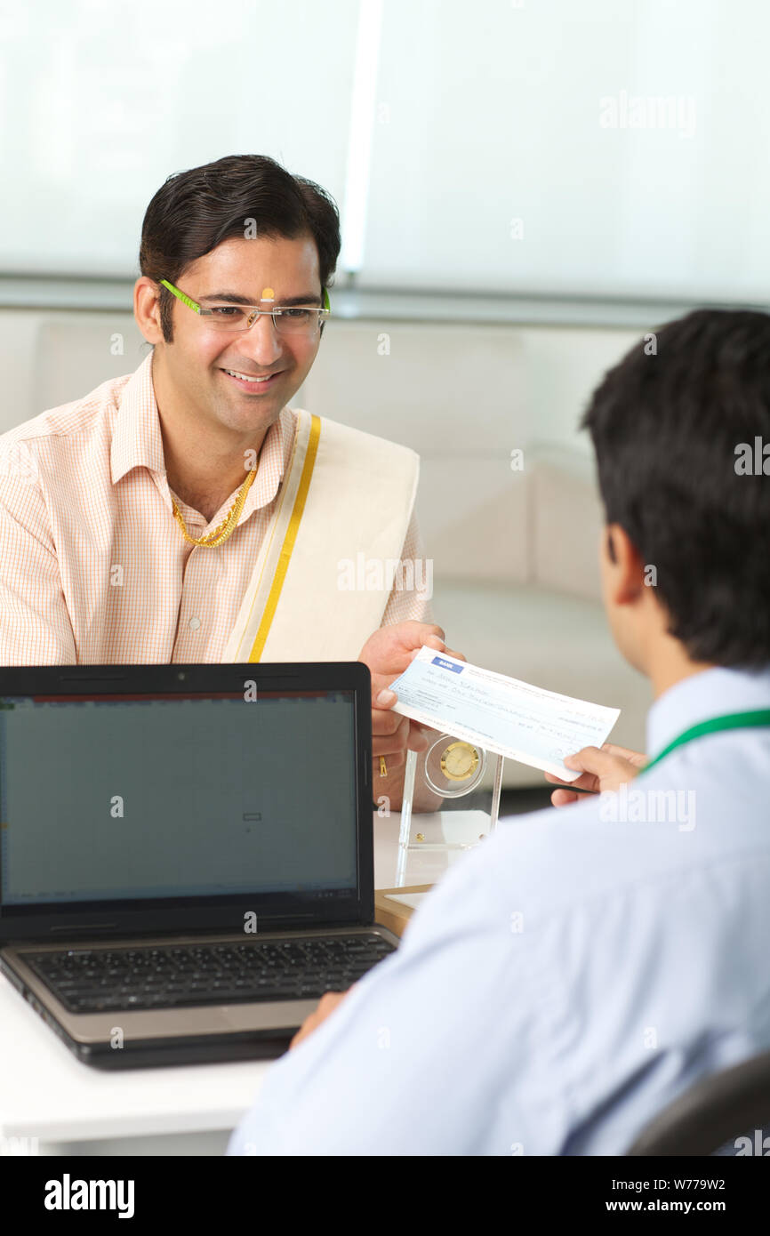 Bank manager giving cheque to his customer as loan Stock Photo - Alamy