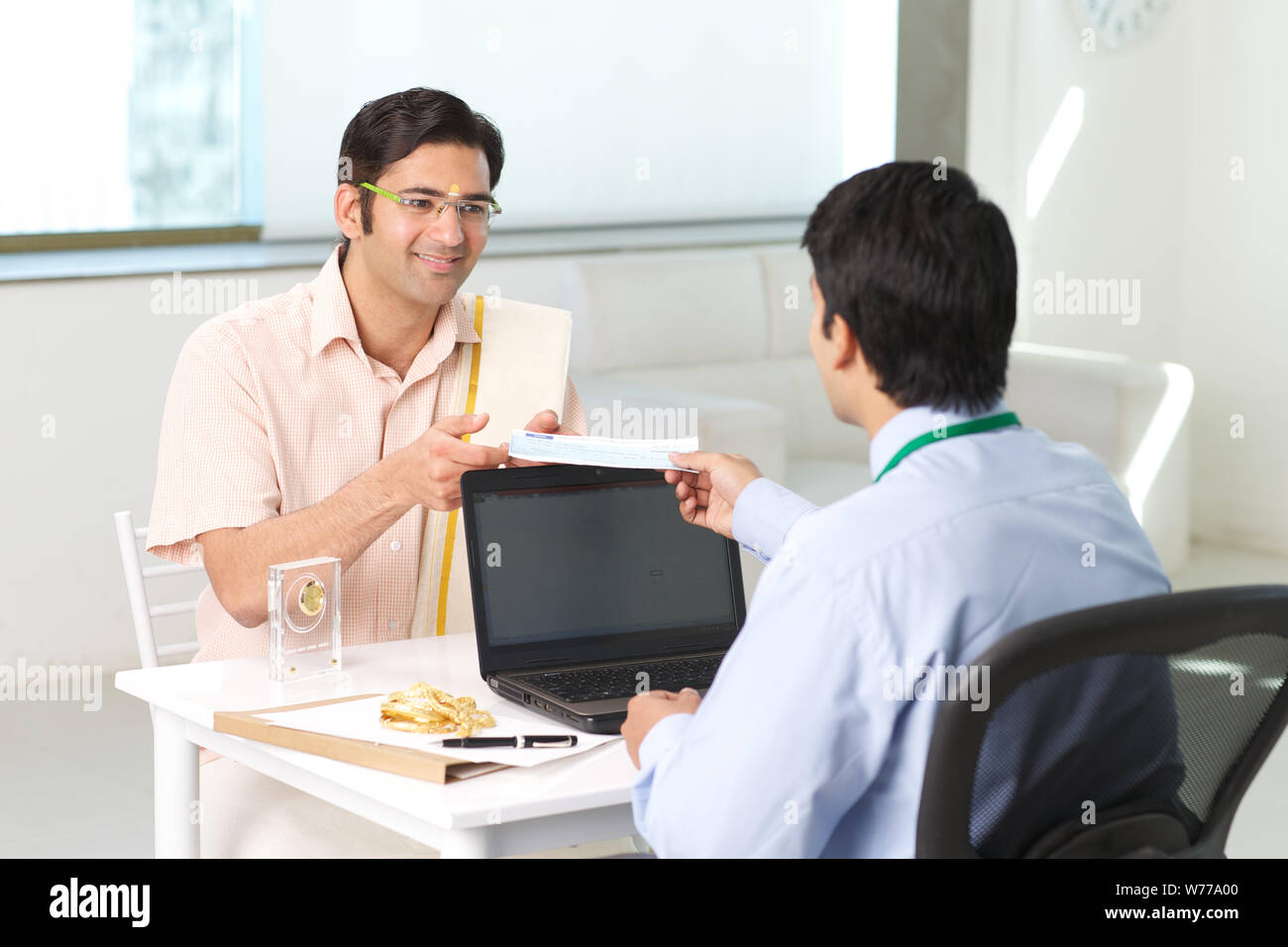 Bank manager giving cheque to his customer as loan Stock Photo - Alamy