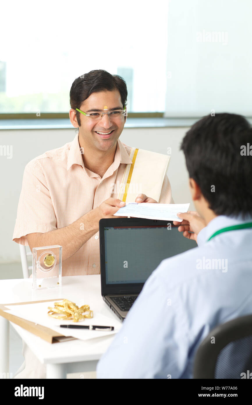 Bank manager giving cheque to his customer as loan Stock Photo - Alamy