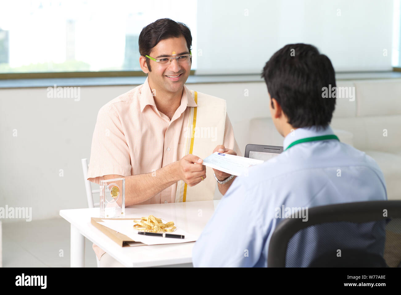 Bank manager giving cheque to his customer as loan Stock Photo - Alamy