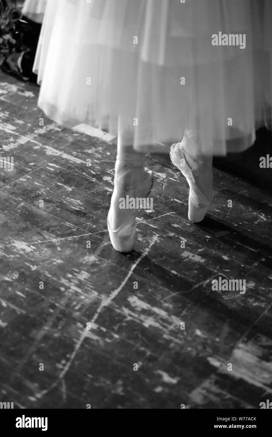 Fragment of the ballerina's movement on the pointe shoes in the rehearsal hall of the theater Stock Photo