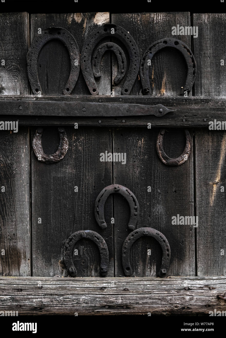 Rustic horseshoe on vintage wooden background. Old horse shoe hanging
