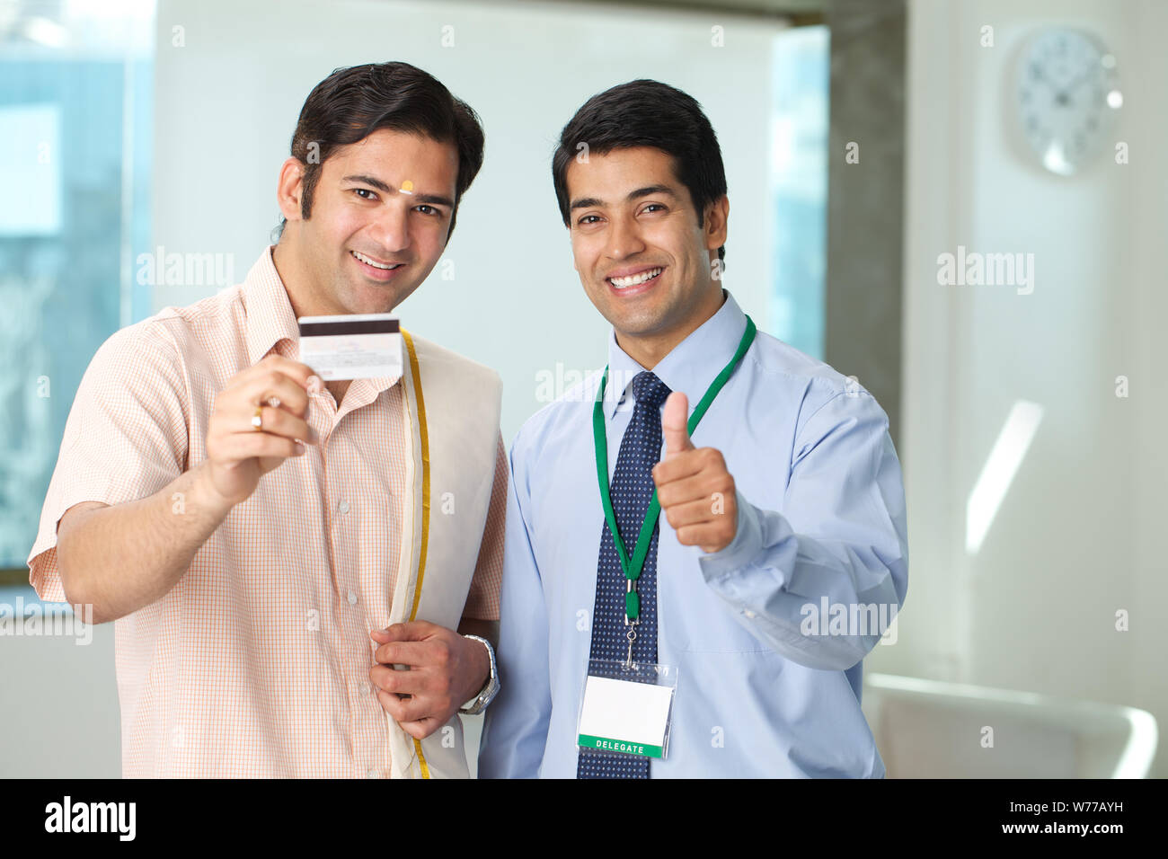 South Indian man showing a credit card while financial advisor showing thumbs up Stock Photo Alamy