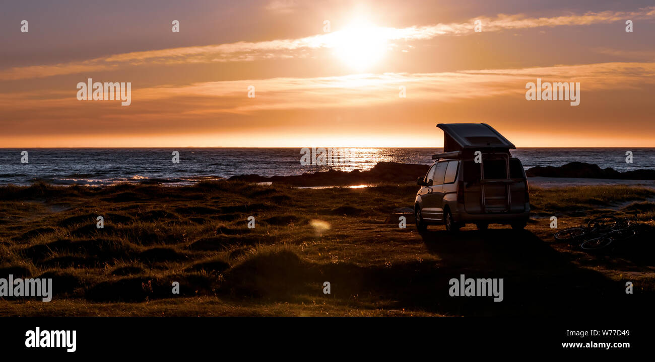Camping car minivan on the beach at sunset. Beautiful Nature Norway natural landscape Lofoten beach. Stock Photo