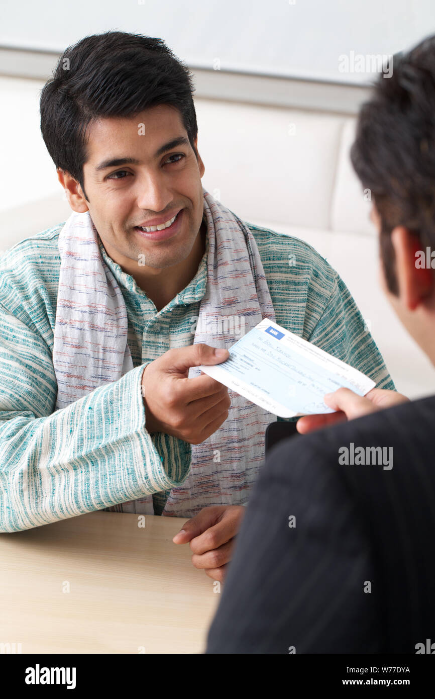 Bank manager giving cheque to his customer as loan Stock Photo - Alamy