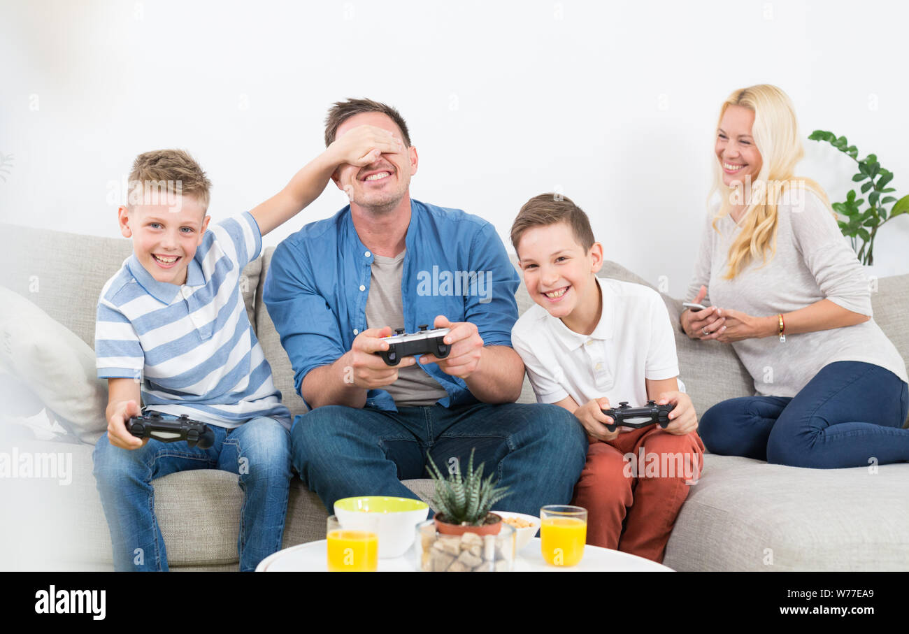 Happy young family playing videogame On TV. Stock Photo