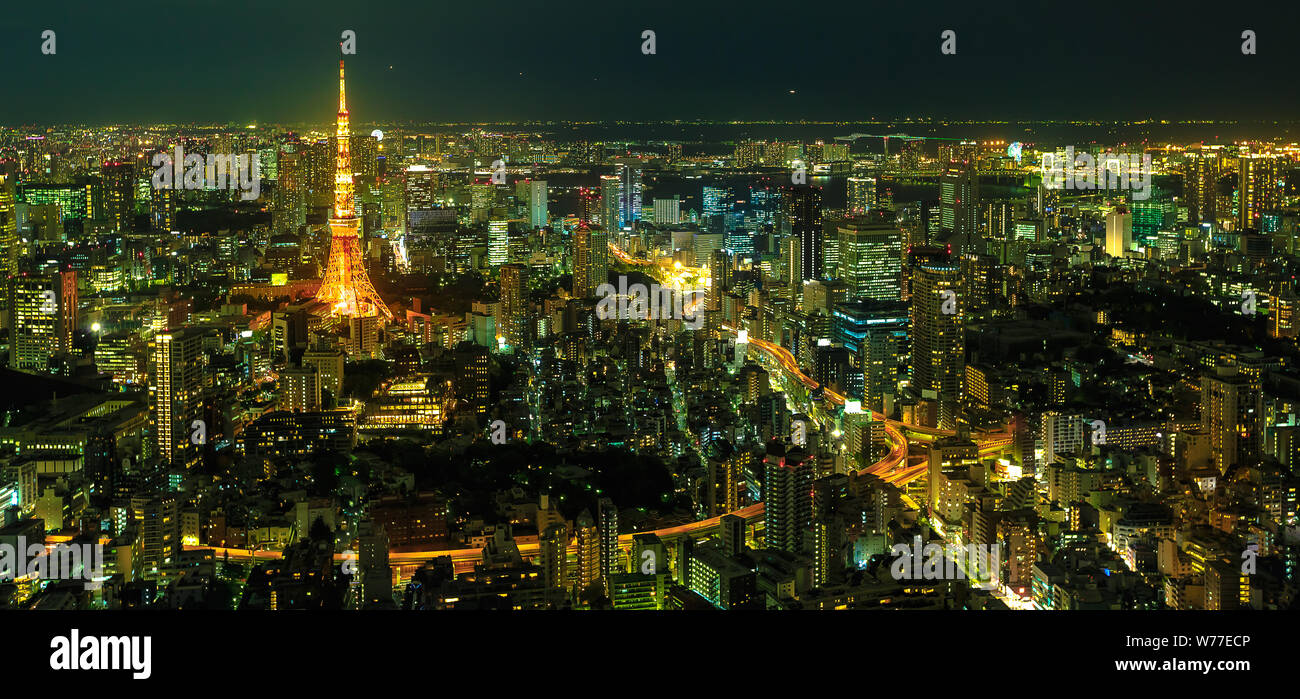 Panorama of Tokyo Skyline at night with illuminated iconic Tokyo Tower from Mori Tower, the modern skyscraper and tallest building of Roppongi Hills Stock Photo