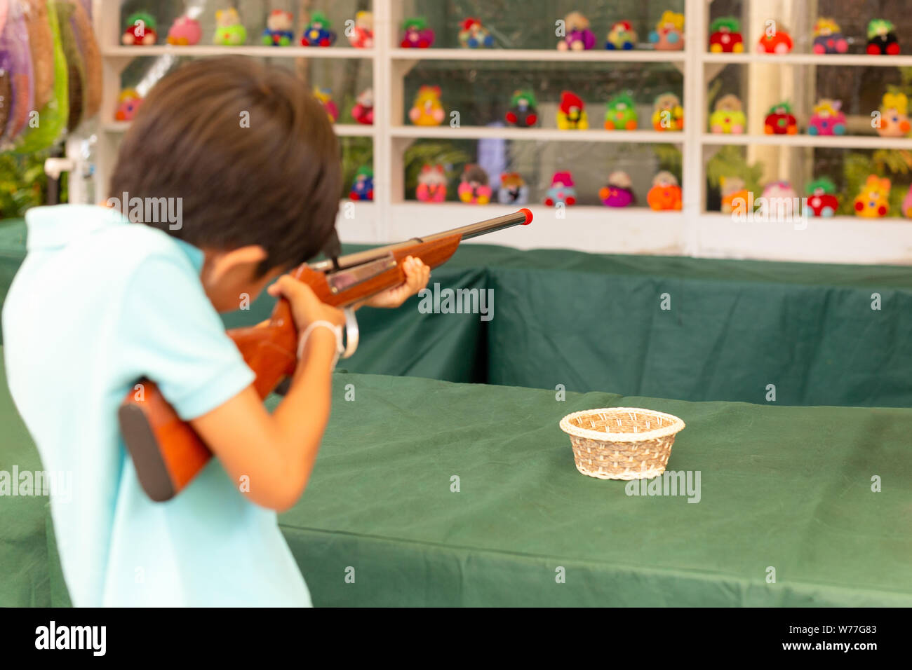 Boy shooting cork gun game at fair. Stock Photo