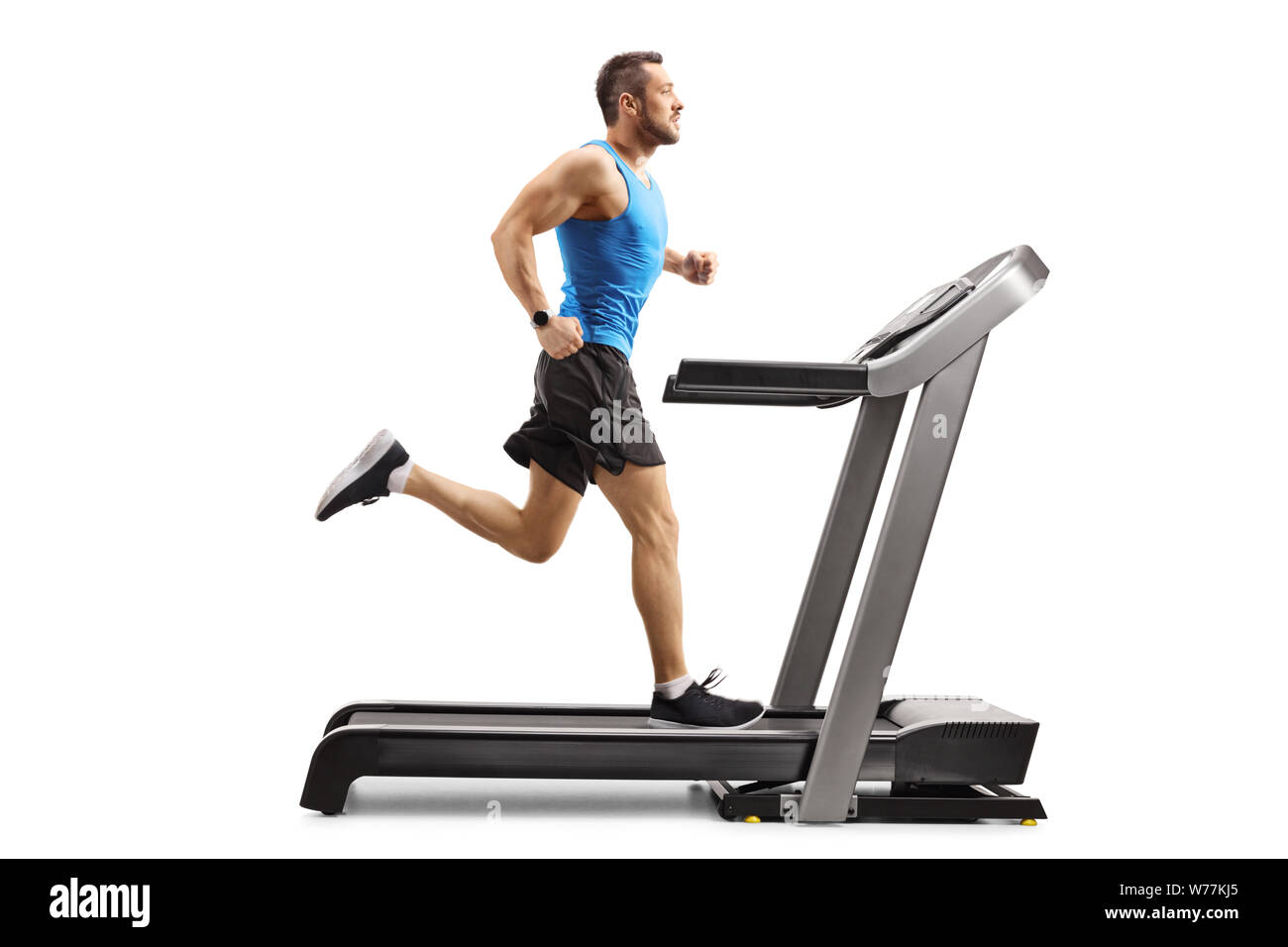 Full length shot of a muscular man running on a treadmill isolated on white background Stock Photo