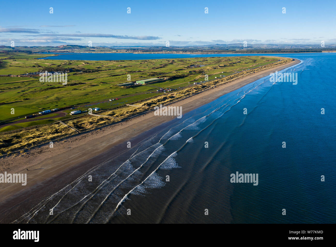 Aerial view of St Andrews' famous West Sands beach with waves rolling in. This peninsula also contains the famous golf links courses. Stock Photo