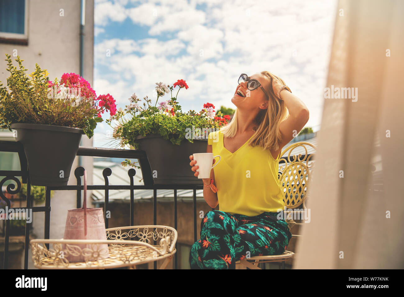 attractive young woman enjoying vacations and drinking coffee on hotel balcony Stock Photo