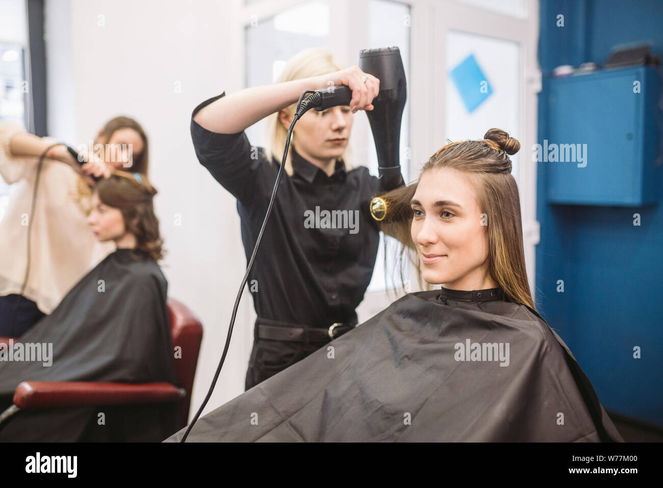 Portrait of happy woman at the hair salon. Professional hair styling ...