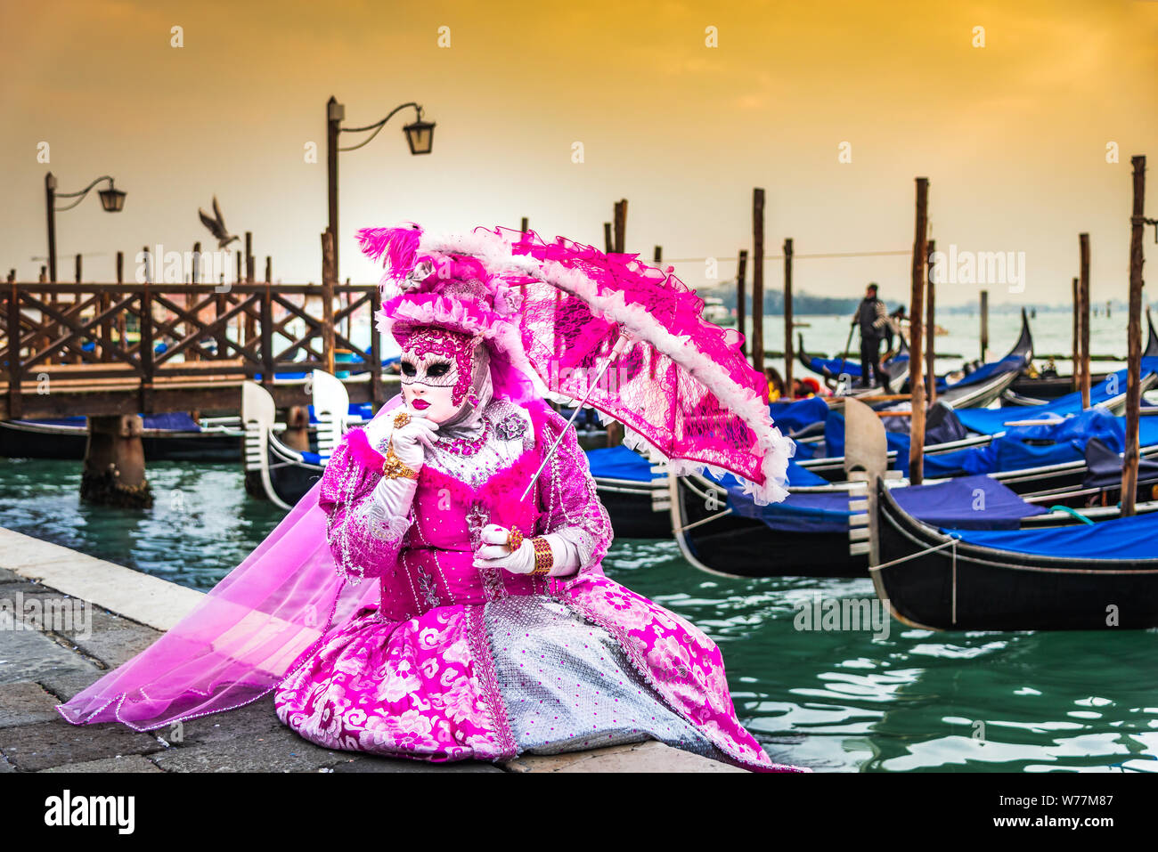 Venice, Italy, Carnival of Venice, beautiful mask at Piazza San Marco with gondolas and Grand Canal. Stock Photo