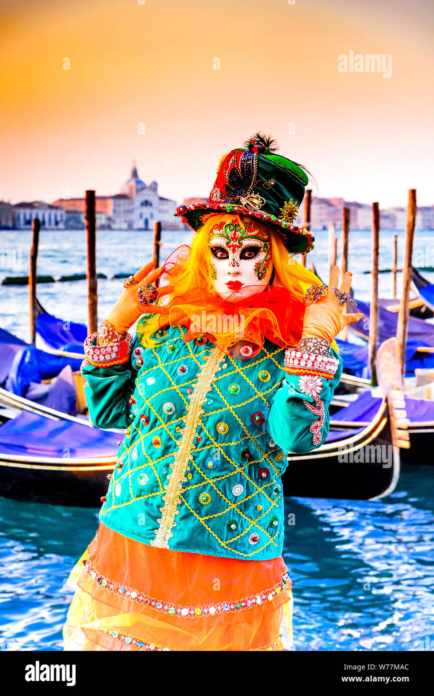 Carnival of Venice, beautiful mask at Piazza San Marco with gondolas and Grand Canal, Venezia, Italy. Stock Photo